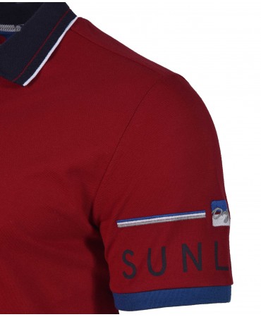 Red polo shirt with blue finish and logo on the Makis Tselios sleeve